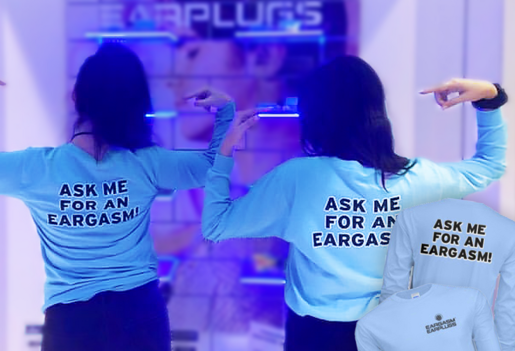 Two women pointing to the backs of their shirts which say 'Ask me for an Eargasm!' ; two pictures of the shirts are in the corner, showing the front and back of the shirt